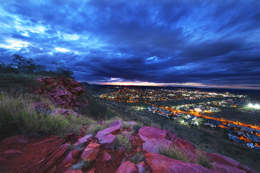 Looking over Alice Springs from Mt Johns as the sun sets in the distance