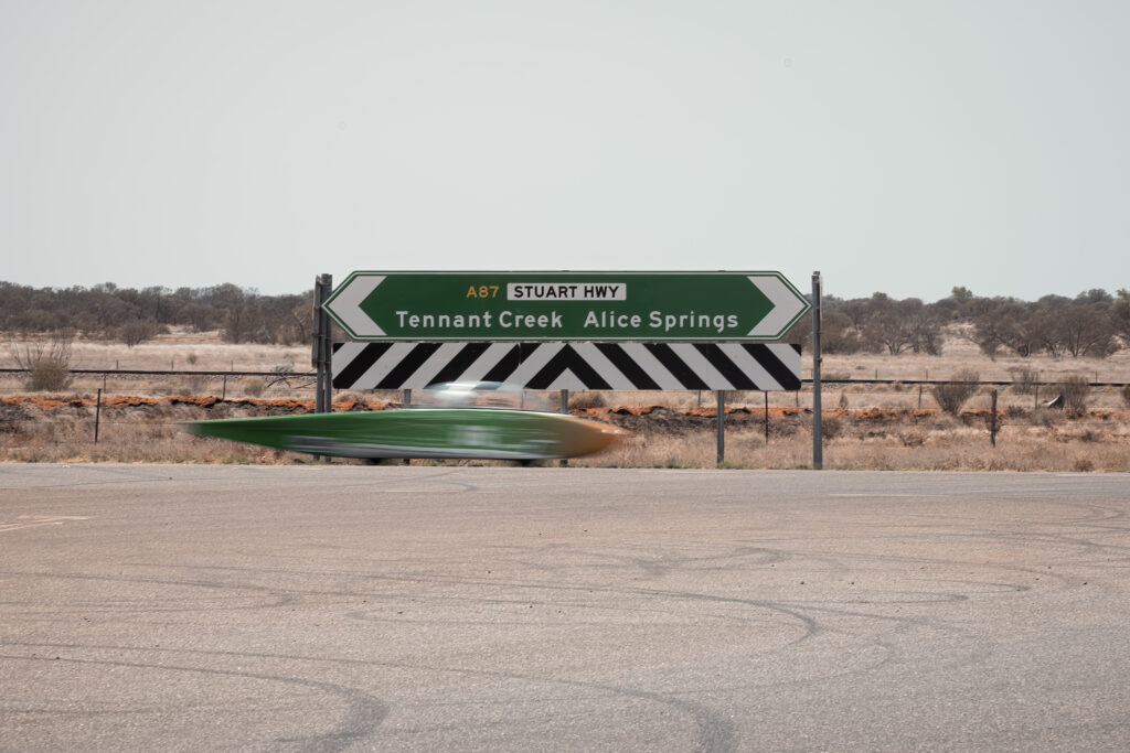 Captivating exploration of a road trip on the A87 Stuart Highway from Tennant Creek to Alice Springs. The image captures the beauty of the tarmac and the allure of the symbolic road signs. This route is renowned for the Bridgestone World Solar Challenge 2023 documented on 'worldsolarchallenge.org'. Experience the stirring landscapes of Australia, way beyond the commonplace.