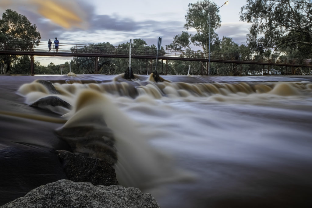 Experience the magical moment at Alice Springs as the Todd River awakens. Witness the rare sight of the river flowing, while a couple stands on a walkway, basking in the golden hues of the afternoon sunset. This rare event brings life to the arid landscape, offering a tranquil backdrop perfect for an evening stroll and reflection. Camera settings: Focal Length: 24mm ISO: 100 Shutter speed: 30 seconds Aperture: f22